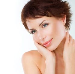 Woman with glowing, youthful skin holding palm to cheek